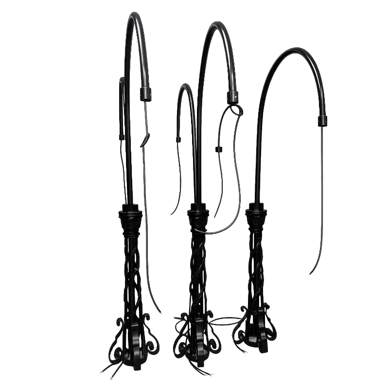 Three restored ornate black metal outdoor lighting pillars with curved swan-neck brackets undergoing refurbishment and rewiring.